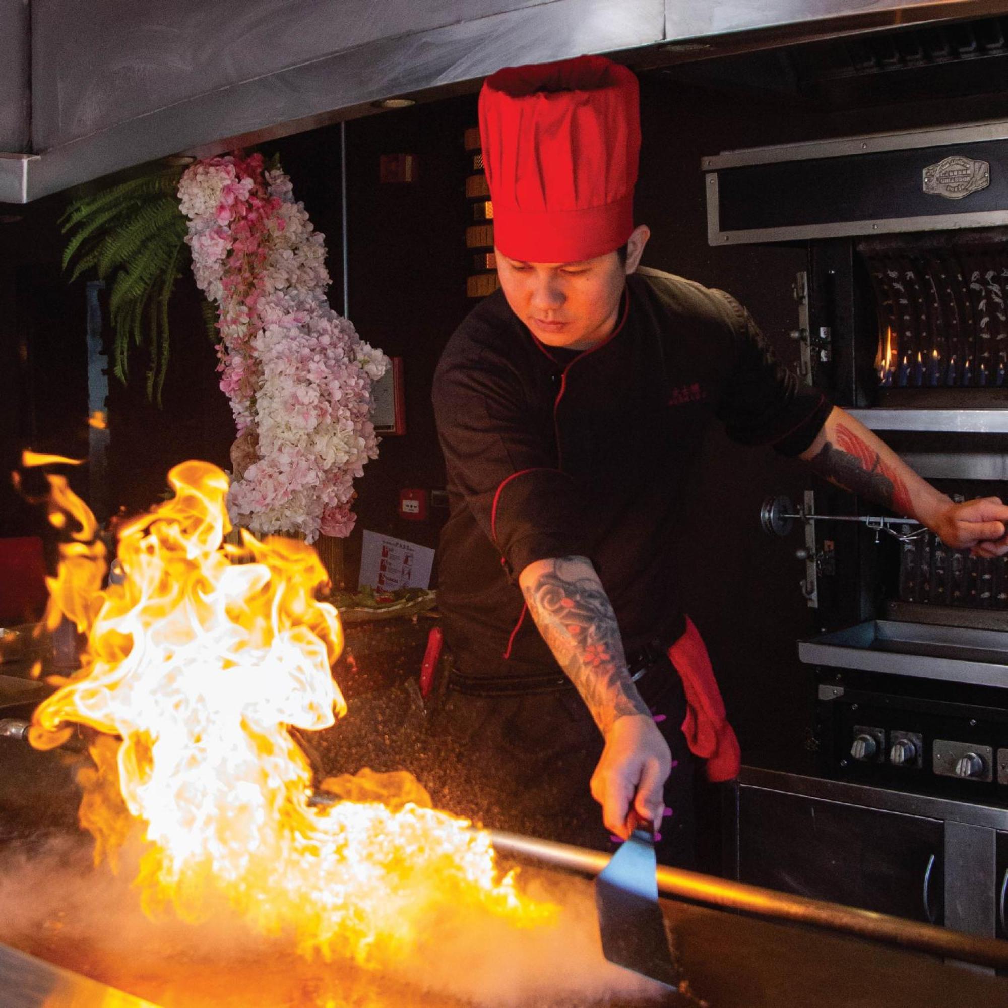 Royal Saray Resort Manama Exterior foto A chef cooking with a flaming torch
